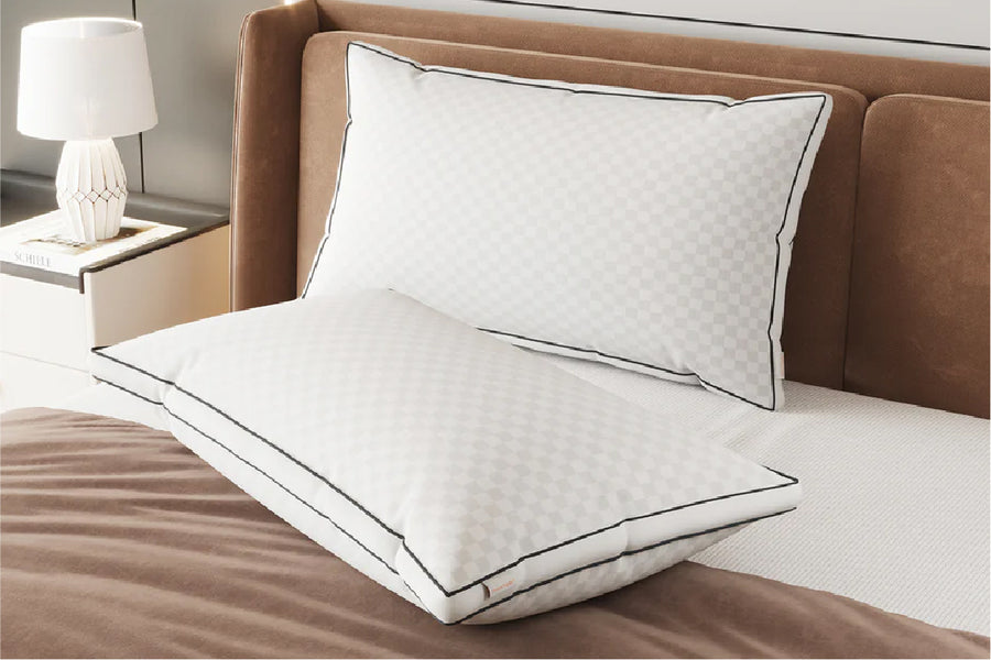 Comfort Support Pillow 2-Pack: two white pillows with checkered pattern and black piping on a bed.