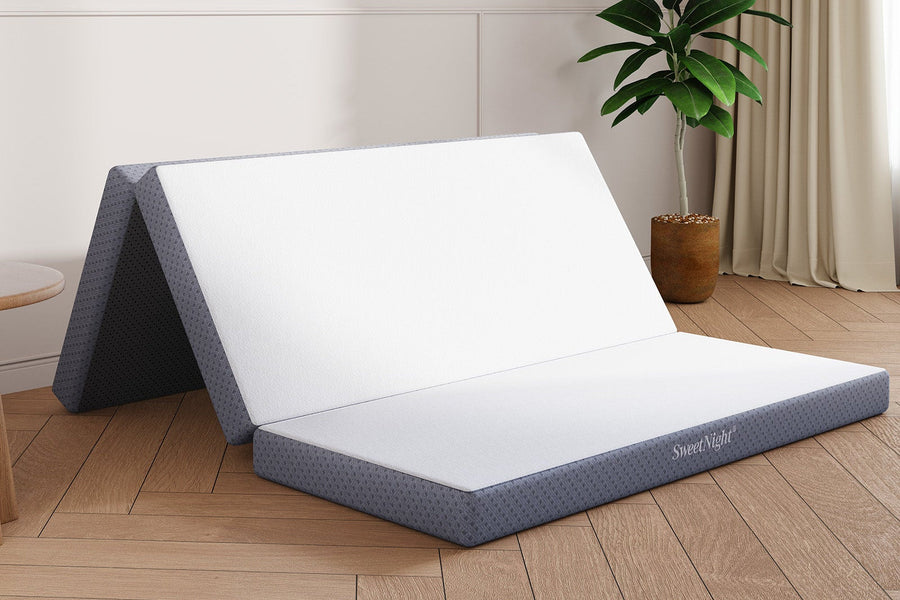 Tri-folding mattress topper, white top, gray base with SweetNight logo, shown partially unfolded for portability.